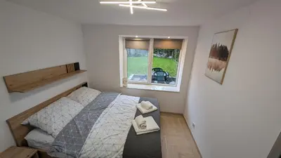 a small bedroom with a bed and a window at Centrum BAL Apartment in Kraków
