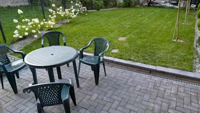 a table and chairs with a table and a lawn at Centrum BAL Apartment in Kraków