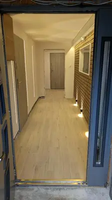 an empty room with a wooden floor and a hallway at Centrum BAL Apartment in Kraków