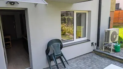 a green chair sitting on a porch next to a window at Centrum BAL Apartment in Kraków