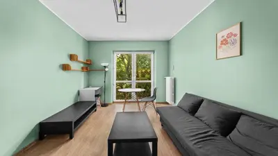 a living room with a couch and a table at Grzegórzki Comfort Apartment by BookingHost in Kraków