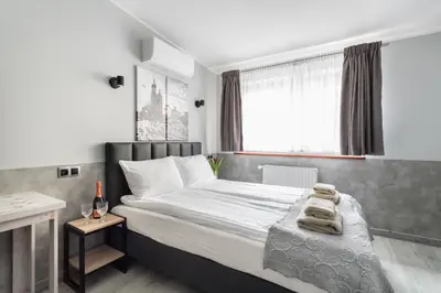 a white bedroom with a large bed with towels on it at NEXT TO Royal Castle Elegant Apartments Kraków Old Town in Kraków