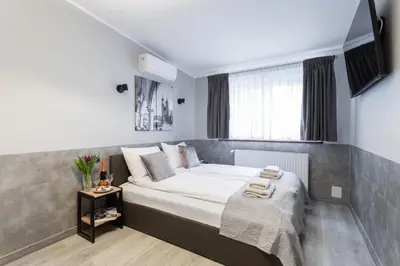 a white bedroom with a bed and a dining table at NEXT TO Royal Castle Elegant Apartments Kraków Old Town in Kraków