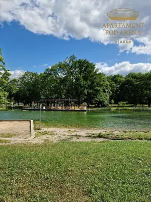 a view of a lake with a food agency sign at Apartament Pod Areną in Kraków