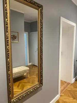 a mirror on a wall with a bench in a room at Gorka Apartament - Old Town Krakow in Kraków
