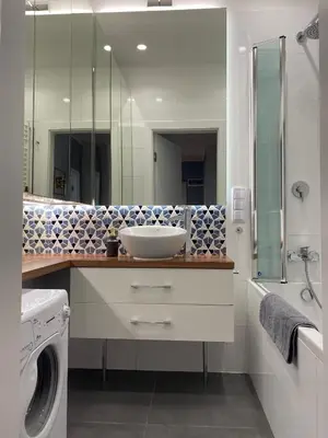 a bathroom with a sink and a washing machine at Gorka Apartament - Old Town Krakow in Kraków