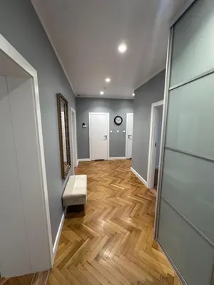 a hallway with wood floors and a door with a bench at Gorka Apartament - Old Town Krakow in Kraków