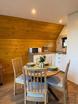 a dining room with a table and chairs in a kitchen at Julianowe Wzgórze in Czchów