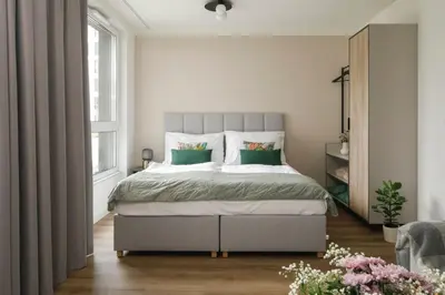 a bedroom with a large bed with green pillows at Zeitraum Raclawicka in Kraków