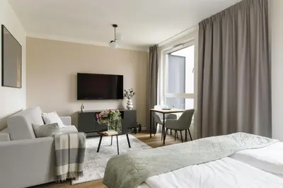 a bedroom with a bed and a living room at Zeitraum Raclawicka in Kraków