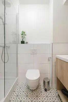 a white bathroom with a toilet and a shower at Zeitraum Raclawicka in Kraków