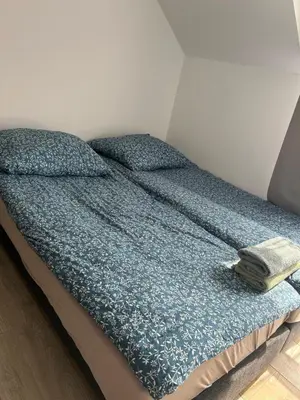 a bed with a blue comforter on top of it at Mieszkanie w zaciszu in Kraków
