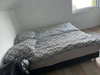 a bed with a black and white blanket on it at Mieszkanie w zaciszu in Kraków