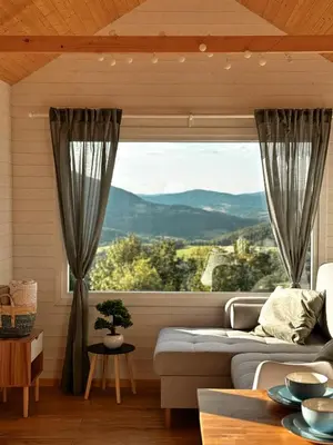 a living room with a couch and a large window at Horyzont Spokoju in Podobin
