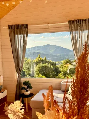 a room with a couch and a large window with a view at Horyzont Spokoju in Podobin