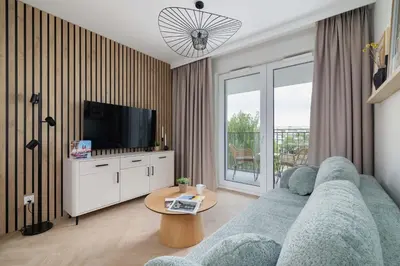 a living room with a blue couch and a tv at Prandoty 10C Cozy Apartment with Balcony & Parking in Krakow by Noclegi Renters in Kraków