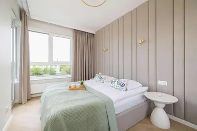 a small bedroom with a bed and a window at Prandoty 10C Cozy Apartment with Balcony & Parking in Krakow by Noclegi Renters in Kraków