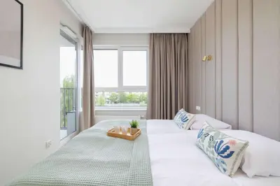 a bedroom with a bed with a tray on it at Prandoty 10C Cozy Apartment with Balcony & Parking in Krakow by Noclegi Renters in Kraków