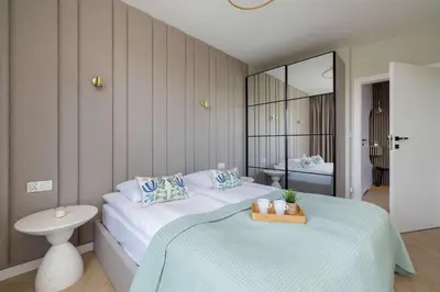 a bedroom with a large white bed and a mirror at Prandoty 10C Cozy Apartment with Balcony & Parking in Krakow by Noclegi Renters in Kraków