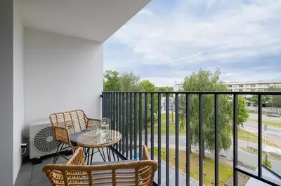 a balcony with a table and chairs and a view at Prandoty 10C Cozy Apartment with Balcony & Parking in Krakow by Noclegi Renters in Kraków