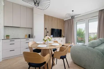 a kitchen and living room with a table and chairs at Prandoty 10C Cozy Apartment with Balcony & Parking in Krakow by Noclegi Renters in Kraków