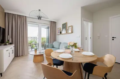 a kitchen and living room with a table and chairs at Prandoty 10C Cozy Apartment with Balcony & Parking in Krakow by Noclegi Renters in Kraków
