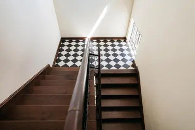 a spiral staircase with a checkered floor at Native Apartments Sobieskiego 19 in Kraków