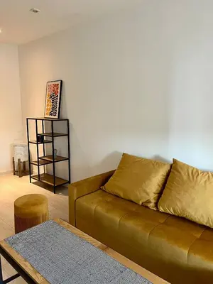 a living room with a brown couch and a table at Apartment Kraków-Stare Miasto in Kraków
