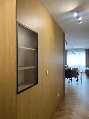 a room with a wall with a mirror and a dining room at Apartament M16 in Limanowa