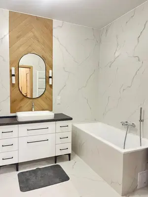 a bathroom with a tub and a sink and a mirror at Apartament M16 in Limanowa