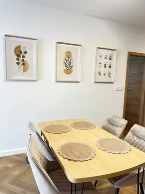 a dining room with a wooden table and chairs at Apartament M16 in Limanowa