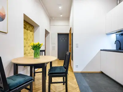 a kitchen and dining room with a table and chairs at Golden Market Square Apartments by Tyzenhauz in Kraków