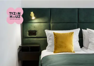 a bed with a green headboard and a yellow pillow at Golden Market Square Apartments by Tyzenhauz in Kraków