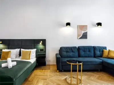 a living room with a bed and a couch at Golden Market Square Apartments by Tyzenhauz in Kraków