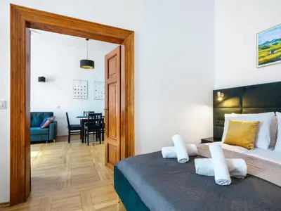 a bedroom with a bed and a dining room at Golden Market Square Apartments by Tyzenhauz in Kraków