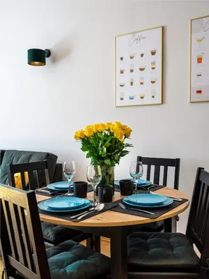 a dining room table with a vase of flowers on it at Golden Market Square Apartments by Tyzenhauz in Kraków
