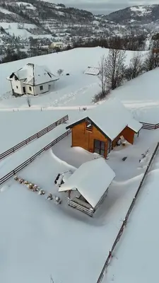 a house covered in snow on a snowy hill at Domek całoroczny w Porębie wielkiej z widokiem na góry in Poręba Wielka