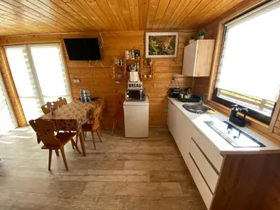 a kitchen and dining room with a table in a cabin at Domek całoroczny w Porębie wielkiej z widokiem na góry in Poręba Wielka