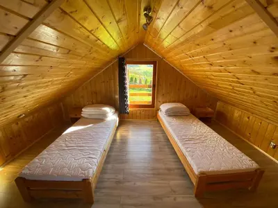 a room with two beds in a wooden cabin at Domek całoroczny w Porębie wielkiej z widokiem na góry in Poręba Wielka