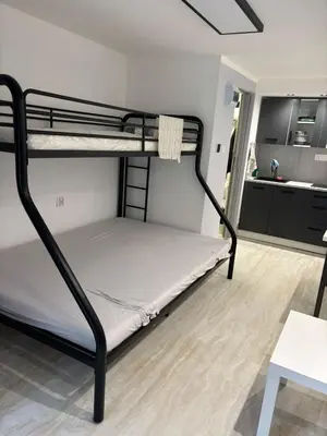 a bunk bed in a room with a kitchen at Apartament 1 w Kocierzu in Kocierz Rychwałdzki