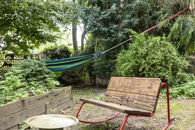 a hammock tied to a bench in a garden at Apartament 294 W Cieniu Drzew by BookingHost in Giebułtów