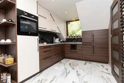 a kitchen with a marble floor and a refrigerator at Apartament 294 W Cieniu Drzew by BookingHost in Giebułtów