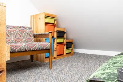 a room with a chair and a book shelf at Apartament 294 W Cieniu Drzew by BookingHost in Giebułtów