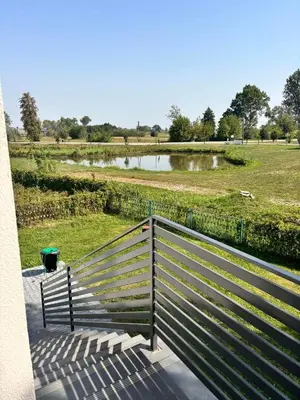 a bench on a balcony with a view of a park at Domki nad Nidą in Wiślica