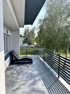 a balcony with a bench on the side of a building at Domki nad Nidą in Wiślica