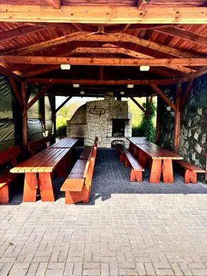 a group of wooden benches sitting under a pavilion at Domki nad Nidą in Wiślica