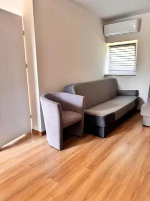 a living room with a couch and a chair at Domki nad Nidą in Wiślica