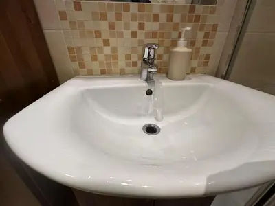 a white sink with a faucet in a bathroom at Dawidapart in Kraków