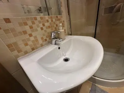 a white sink in a bathroom with a toilet at Dawidapart in Kraków