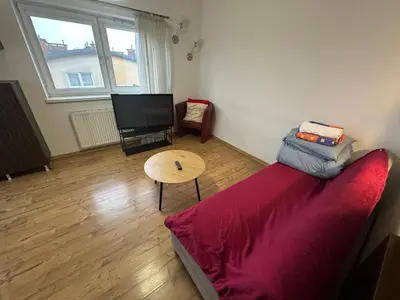 a living room with a red couch and a table at Dawidapart in Kraków
